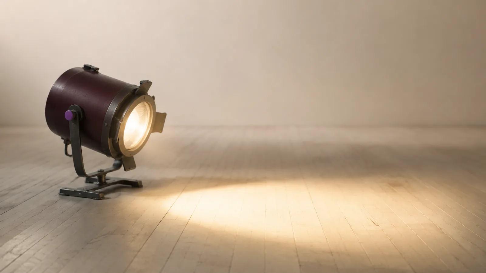 A single theatre spotlight illuminating an empty patch of stage floor.