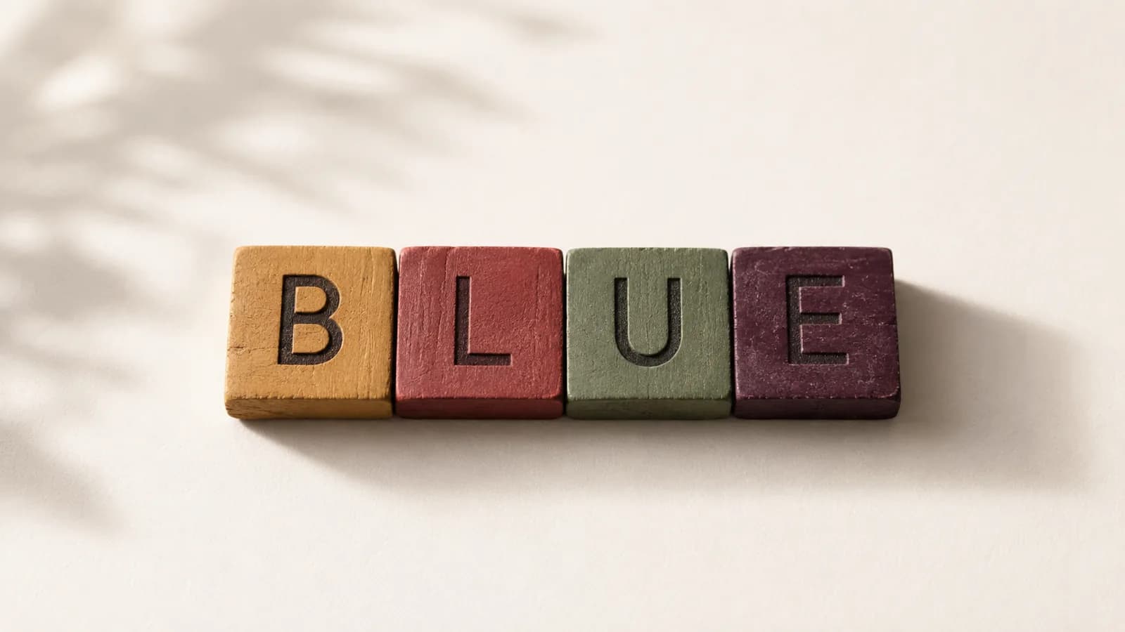 Letter tiles spelling a colour word, each painted a conflicting colour.