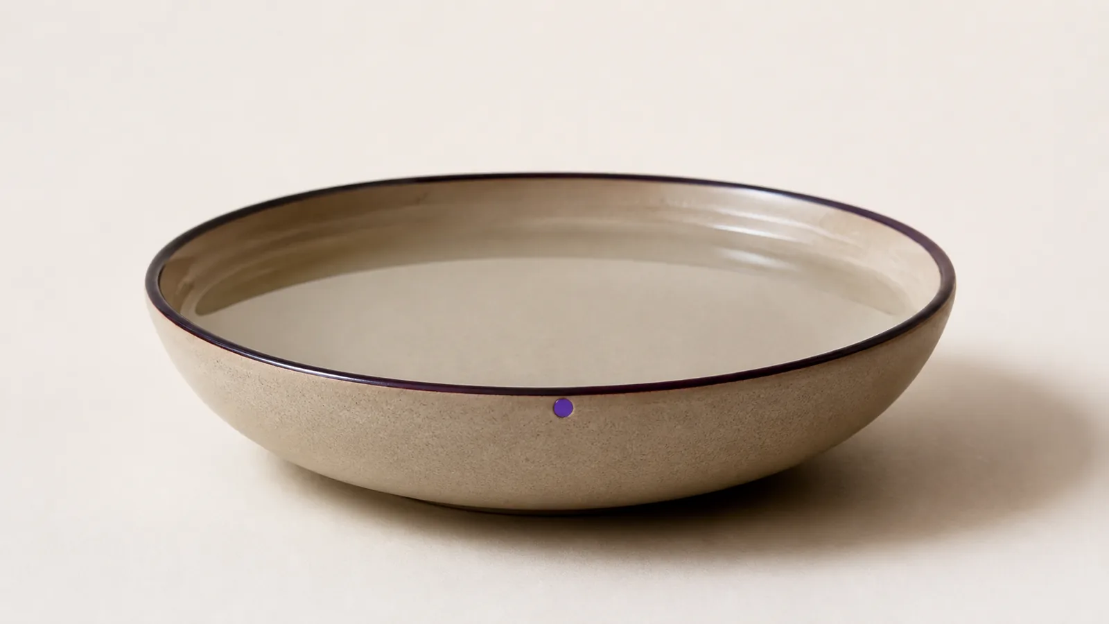 A shallow bowl of clear water with a perfectly still surface.