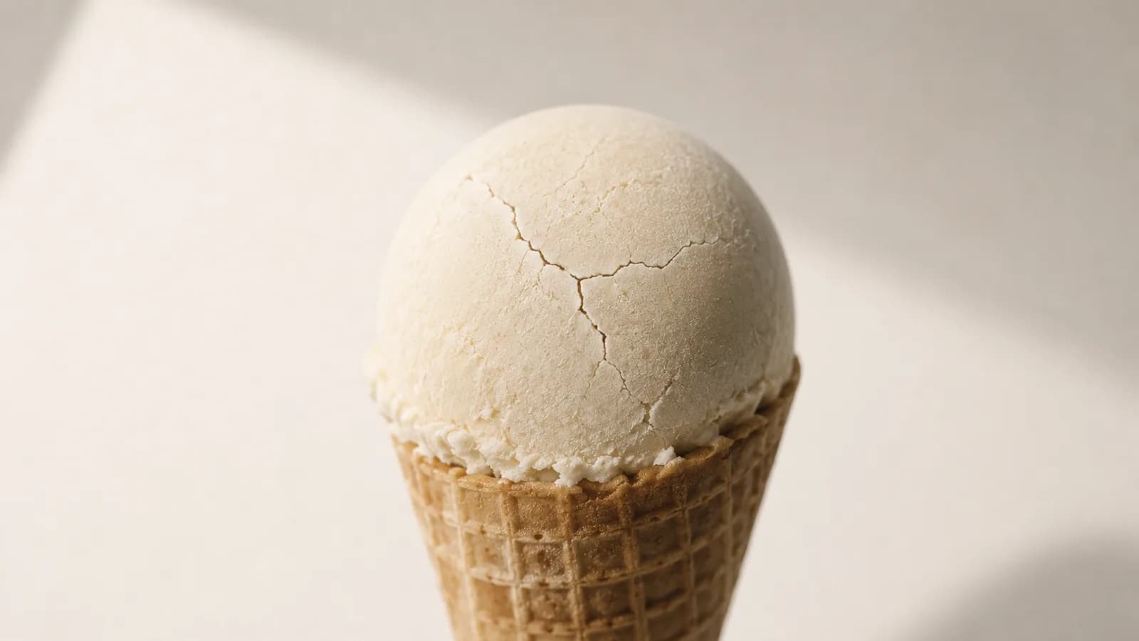 A scoop of ice cream with a hairline crack of frost across its surface.