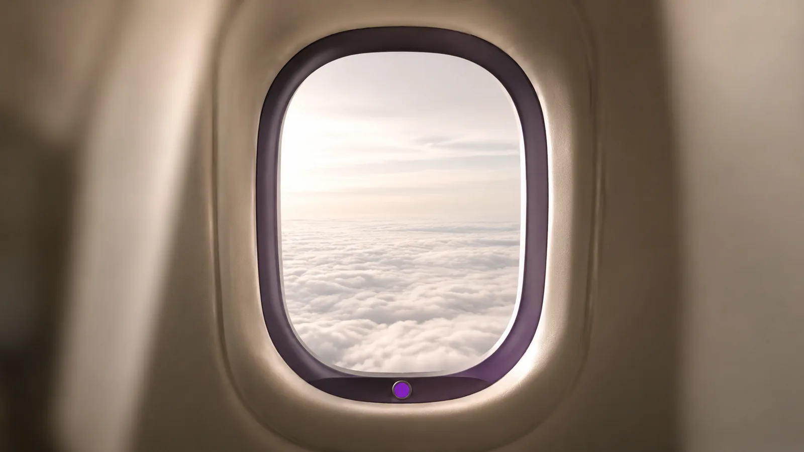 An aircraft window seen from inside with a cloud layer below.